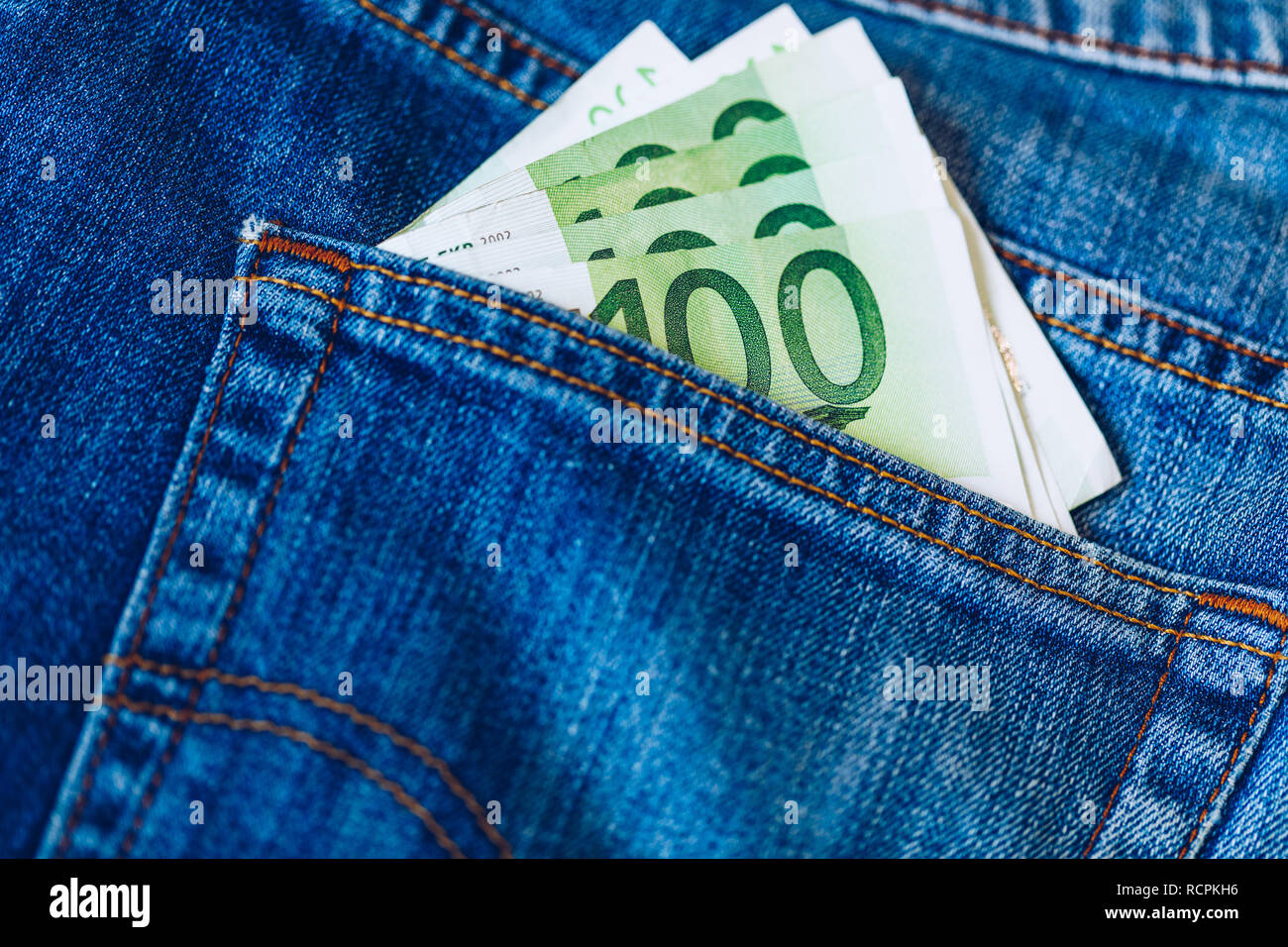 Le fatture in euro in tasca dei jeans sfondo. Le banconote in euro in jeans tasca posteriore. Concetto di gente ricca, salvataggio o spendere soldi. Euro Bills cadano fuori. Foto Stock