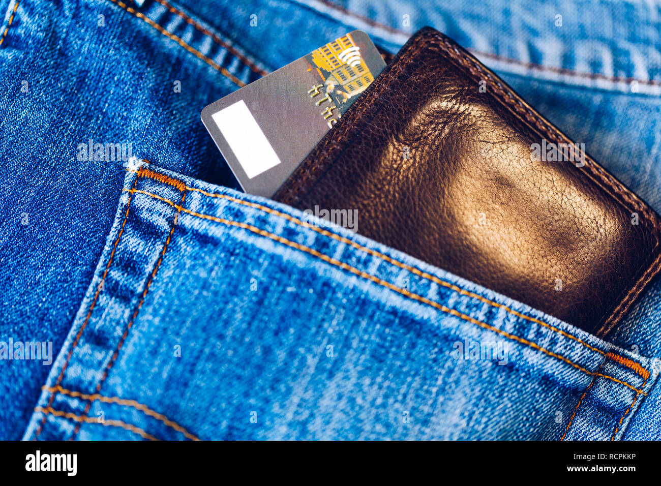 Carta di credito nel portafogli nella tasca dei jeans, primo piano. Vista dettagliata del portafoglio e la carta di credito in jeans pantaloni tasca. Foto Stock