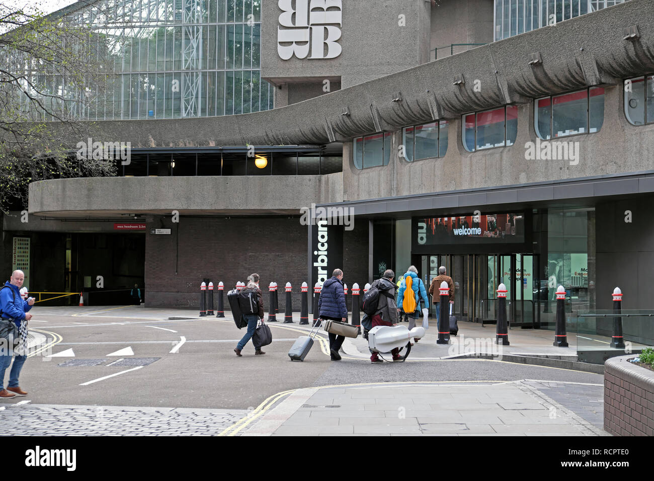 I musicisti professionisti che arrivano con strumenti musicali presso il Barbican Centre entrata in seta Street London EC2Y UK KATHY DEWITT Foto Stock