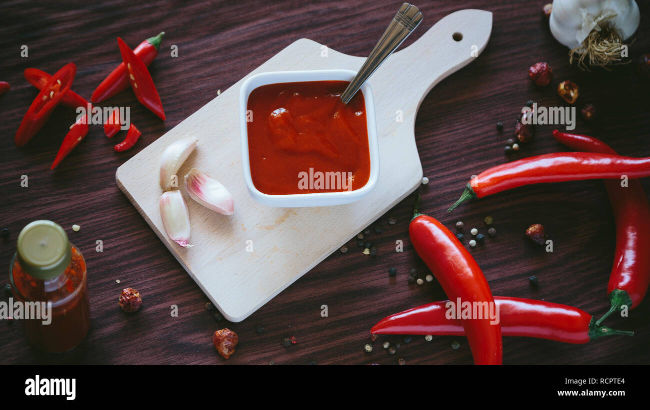 In casa la salsa calda in una ciotola bianco su uno sfondo di legno Foto Stock