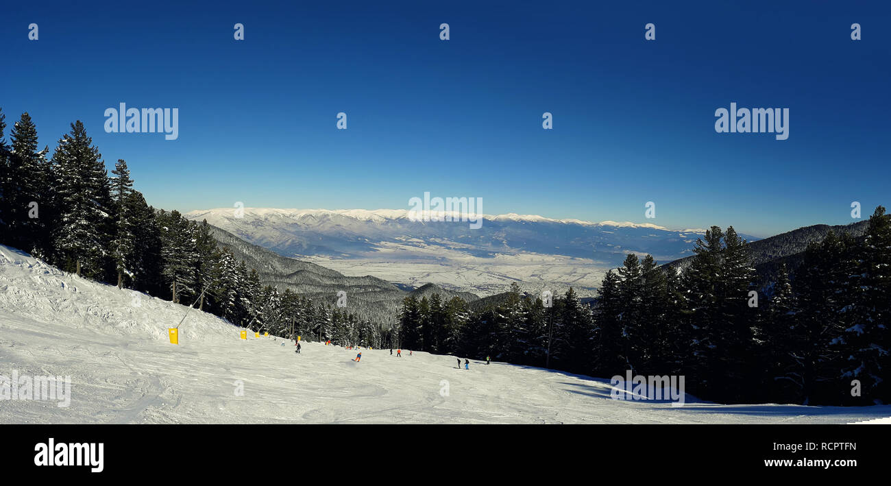 Bansko resort vista panoramica con pista da sci nella foresta e alberi di neve, Bulgaria Foto Stock