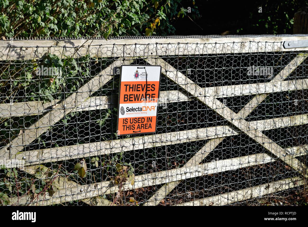 Segno su un cinque bar porta nella campagna di avvertimento ladri 'Attenzione' marcatura forense in uso nel settore, Surrey Hills Inghilterra REGNO UNITO Foto Stock