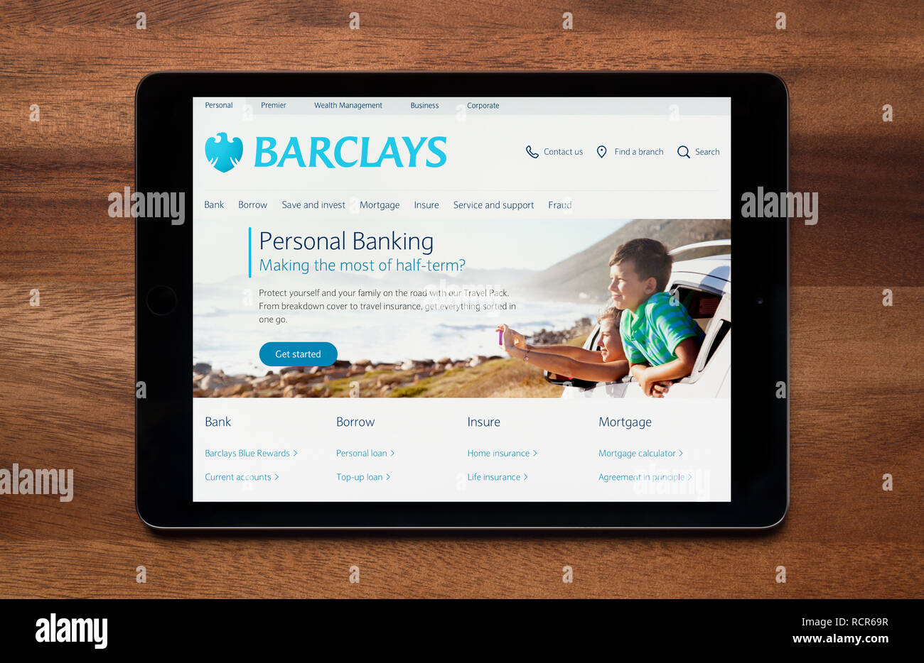 Il sito web di Barclays Bank è visto su un tablet iPad, il quale è appoggiato su un tavolo di legno (solo uso editoriale). Foto Stock