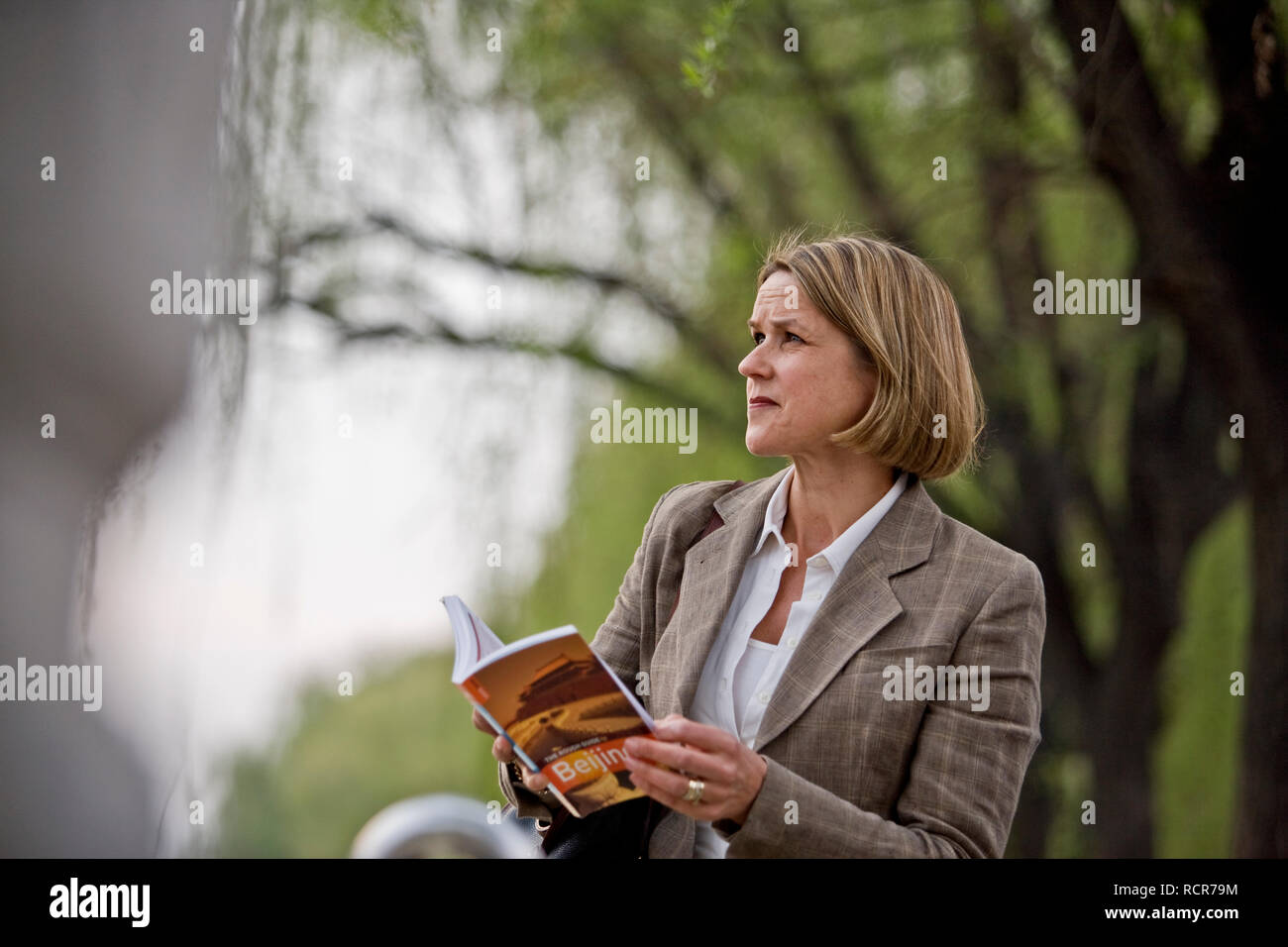 Donna matura tenendo un libro guida. Foto Stock