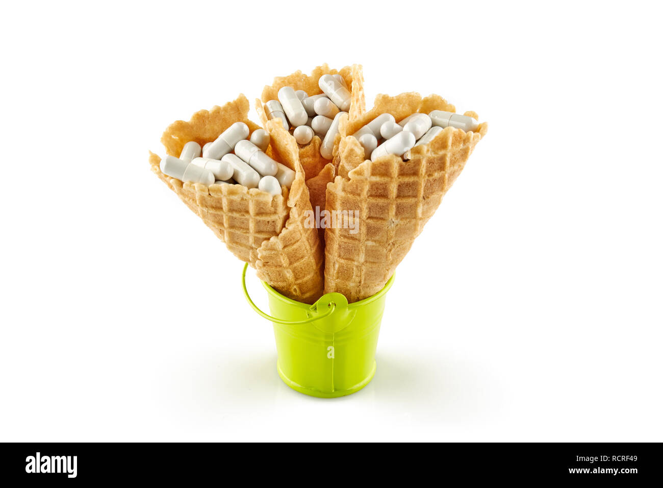 Il gelato coppe con la medicina nel verde della benna di piccole dimensioni. Isolato su sfondo bianco. Foto Stock