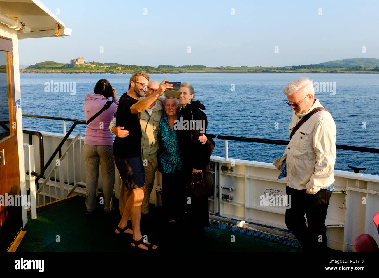 La famiglia e gli amici prendere selfie fotografia a bordo di traghetti tra Oban e Craignure Mull Foto Stock
