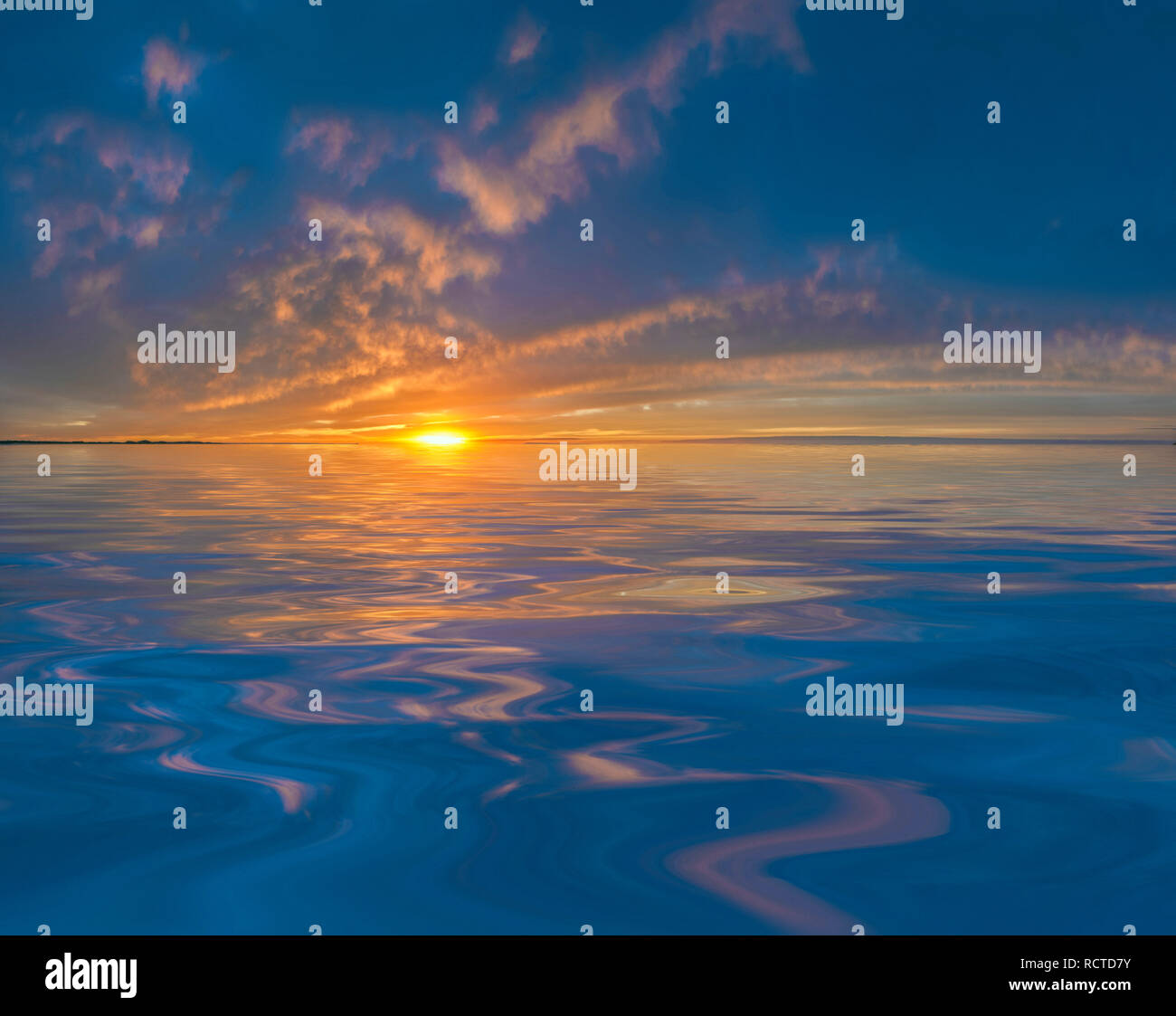 Nuvole al tramonto o all'alba riflesse in acqua calma Foto Stock