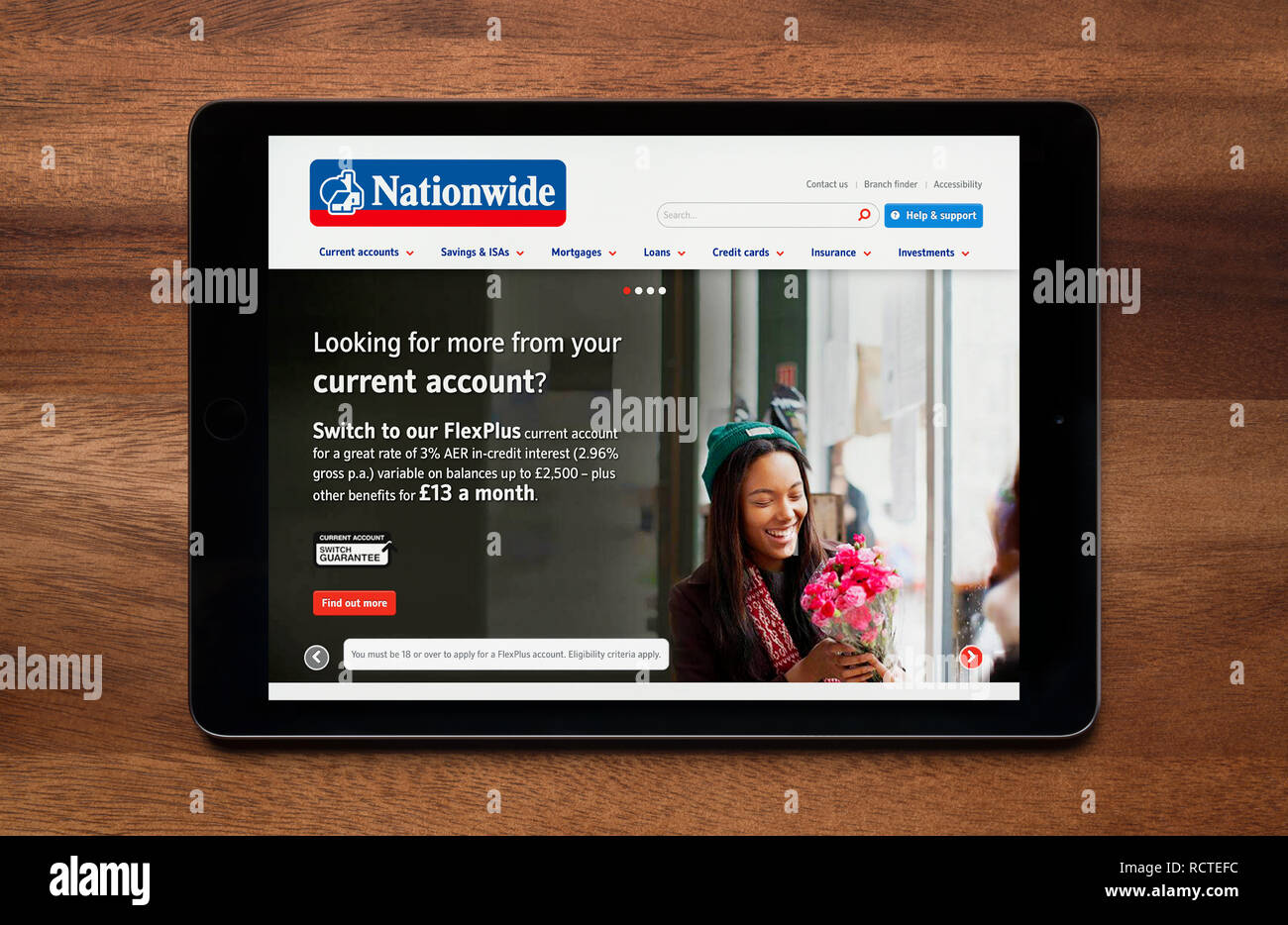 Il sito web di Nationwide Building Society è visto su un tablet iPad, il quale è appoggiato su un tavolo di legno (solo uso editoriale). Foto Stock