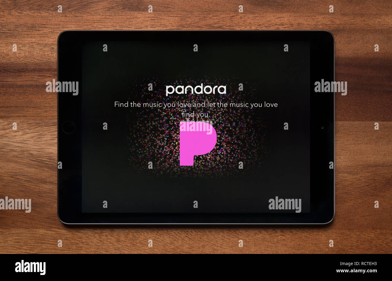 Il sito web di Pandora è visto su un tablet iPad, il quale è appoggiato su un tavolo di legno (solo uso editoriale). Foto Stock