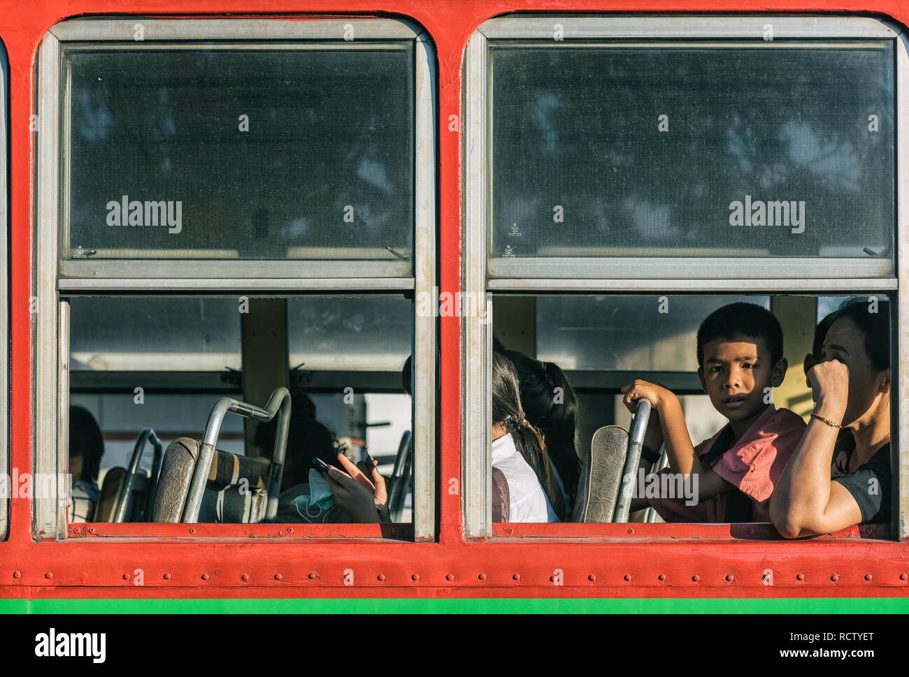 Bangkok, Tailandia - 24 Nov 2018: un ragazzo guardando da una finestra di un bus locale a Bangkok Foto Stock