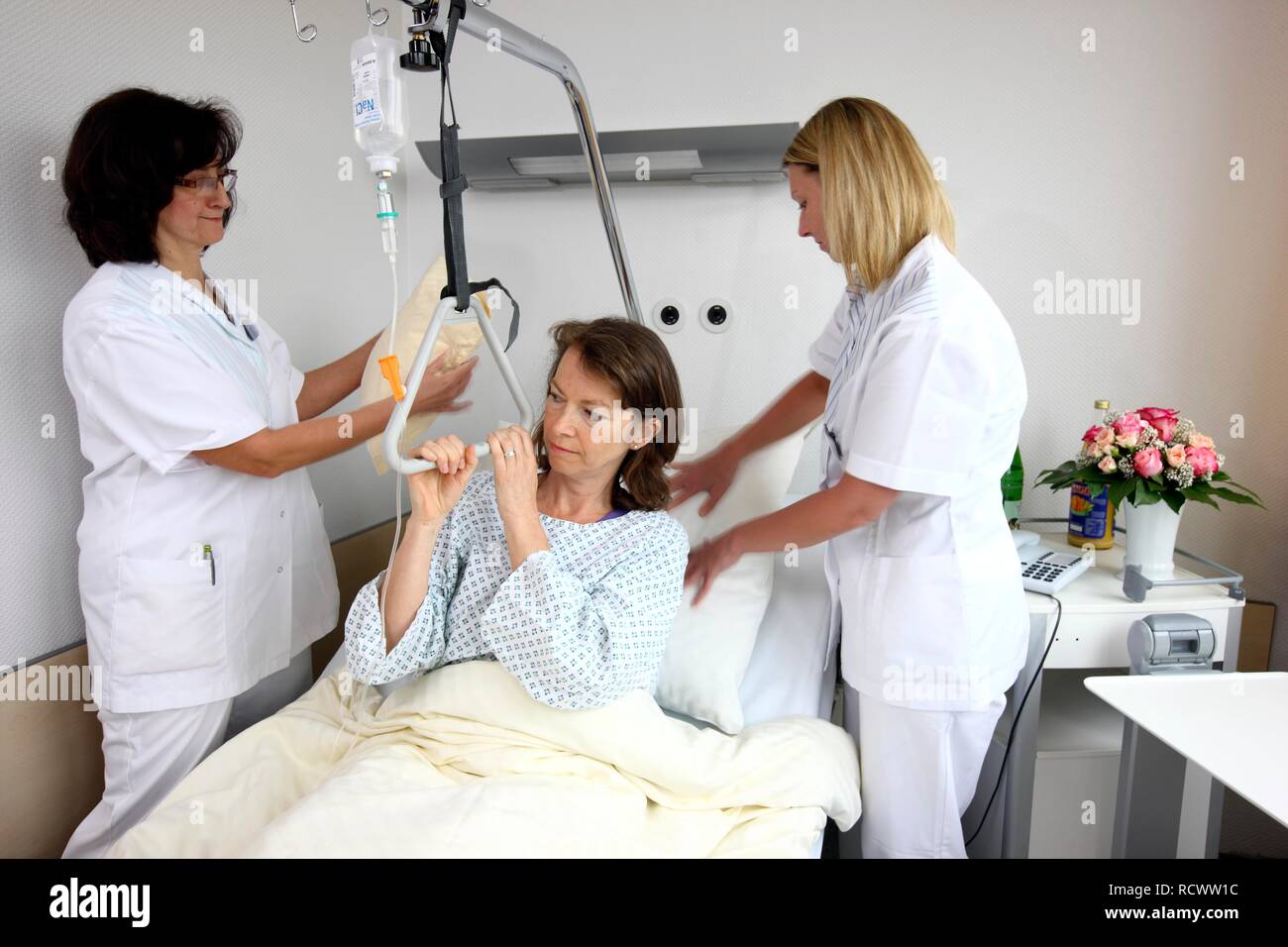 Paziente disteso in un letto di ospedale infermieri, rendendo il letto, camera singola, ospedale Foto Stock