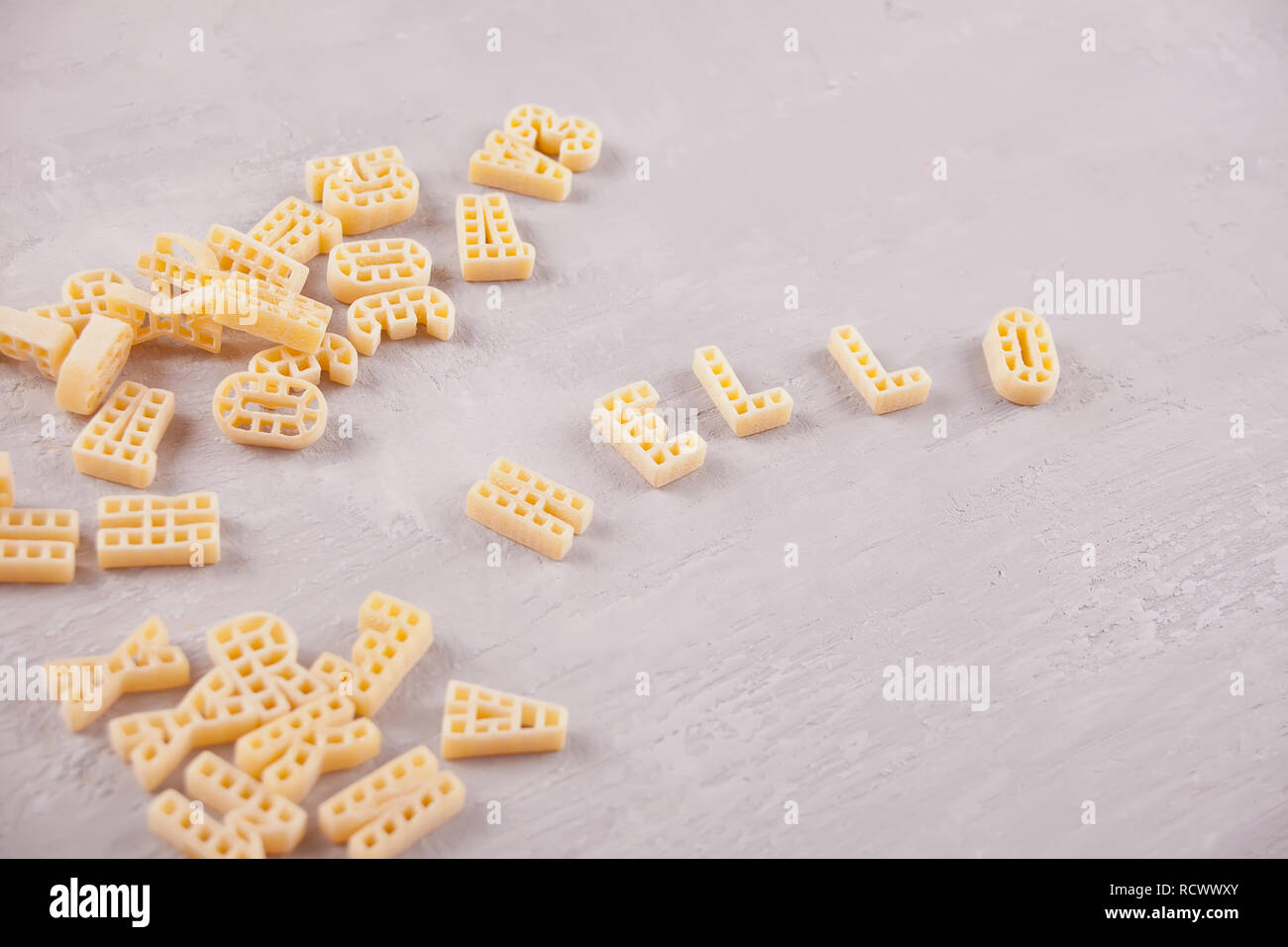 Testo Ciao scritto con maccheroni in forma di lettere su grigio tavolo in legno Foto Stock