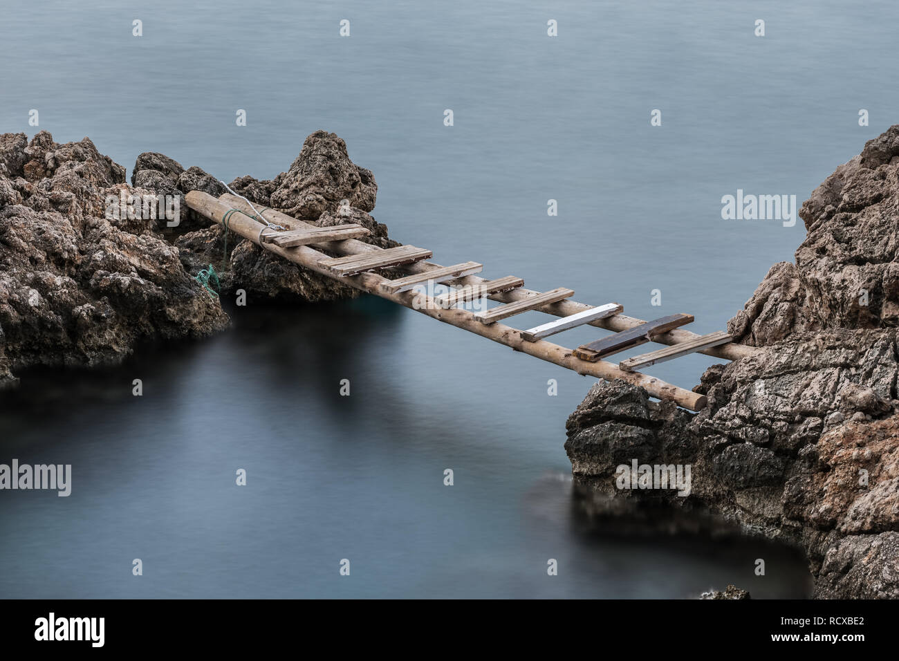 Esposizione lunga scena con vecchie scale di legno usato come un ponte Foto Stock