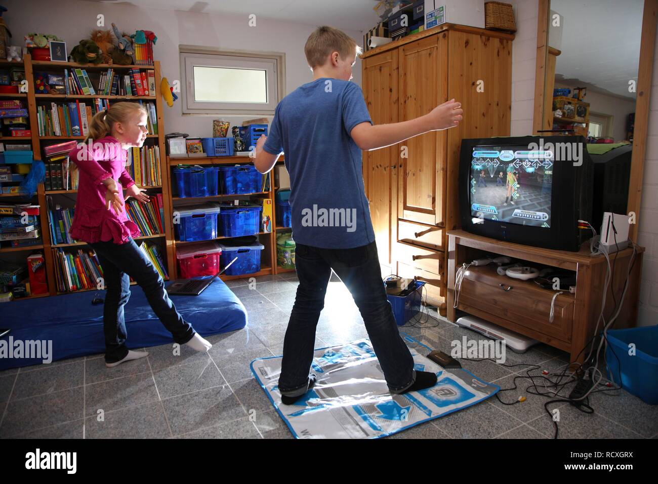 Fratelli, un ragazzo, 12 anni, e una ragazza di 10 anni, la riproduzione di  un gioco di ballo su un Wii console giochi nel loro insieme in camera Foto  stock - Alamy