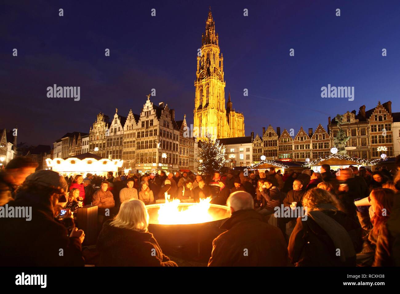 Persone bevendo un vin brulé attorno ad una grande fiamma a gas falò, mercatino di Natale presso il municipio sul Grote Markt Foto Stock