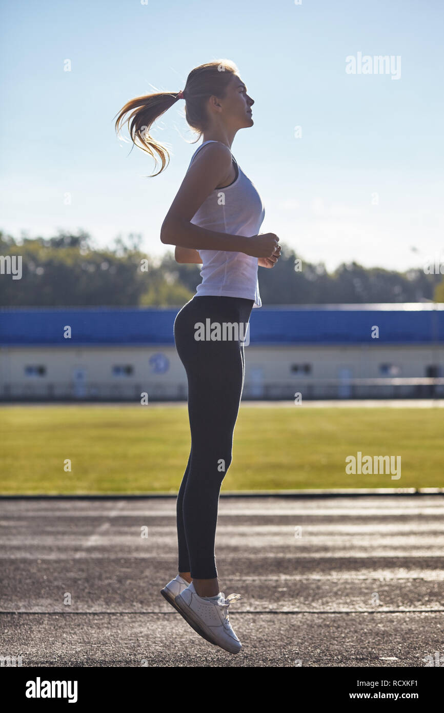 Una giovane donna con fit jumping. Foto Stock