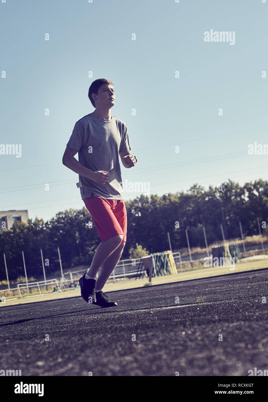 Uomo sportivo jogging al parco nella luce di sunrise Foto Stock