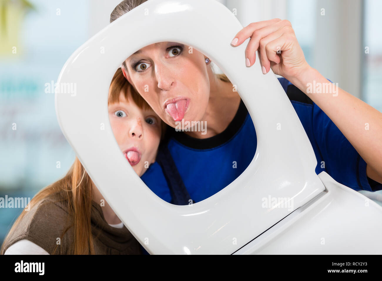 Divertente il ritratto di una donna e di sua figlia guardando la telecamera thr Foto Stock