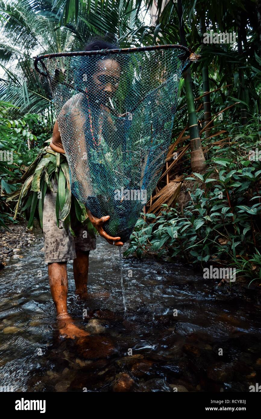 Muara Siberut, isole mentawai / Indonesia - 15 AGO 2017: tribal stati lady pesca di Small Fry e gamberetti nella giungla stream Foto Stock