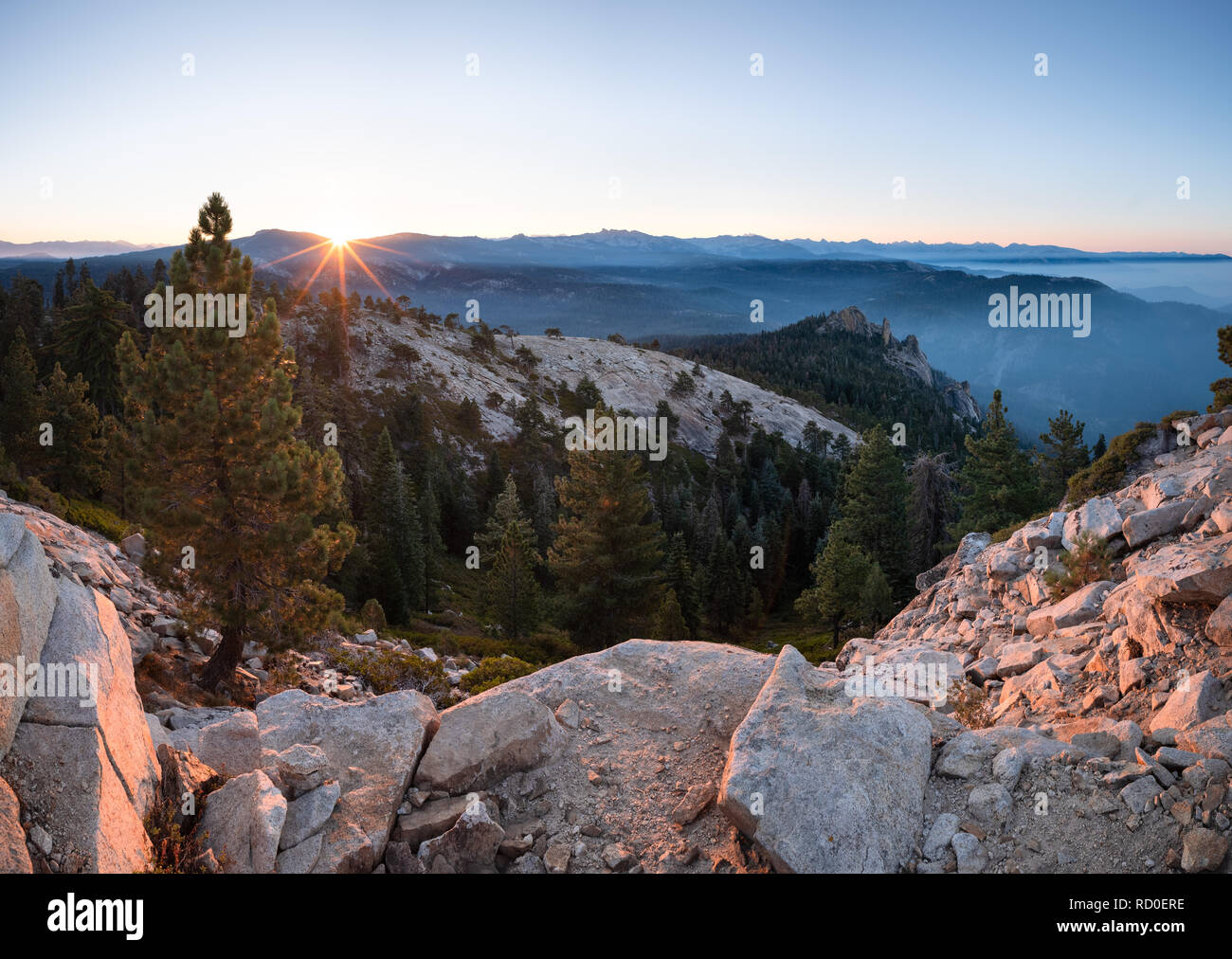 Sunrise e opacità del fumo sulla catena montuosa della Sierra Nevada e il camino Rock dal grande Baldy, Sequoia National Park, California, Stati Uniti Foto Stock