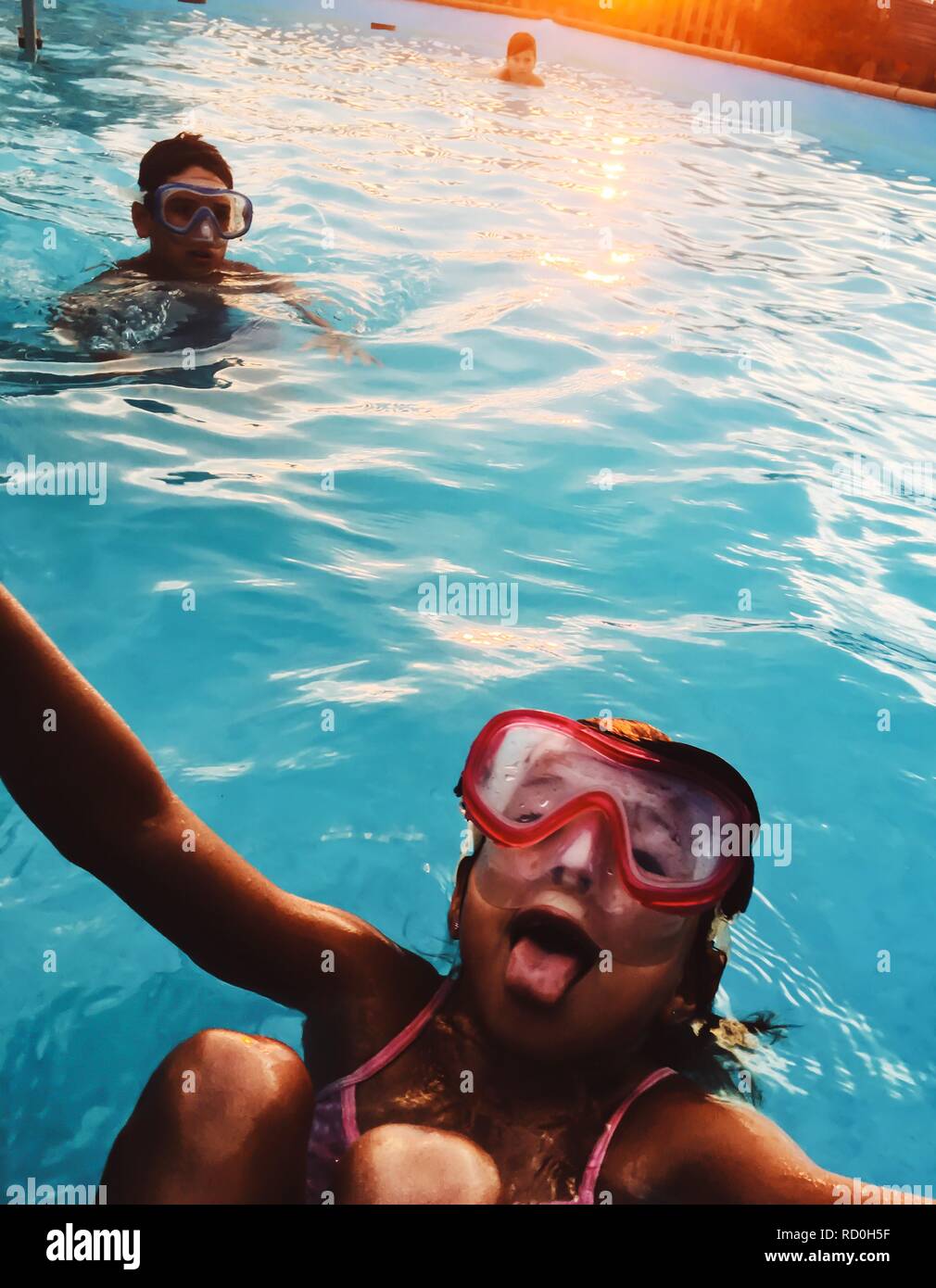 Tre bambini messing about in una piscina Foto Stock