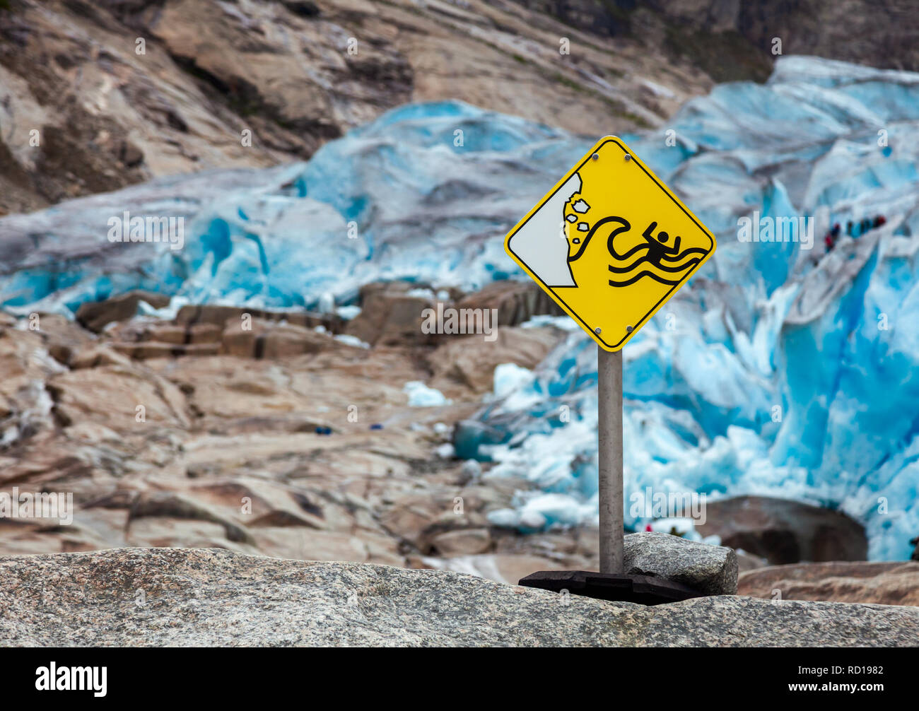 Pericoloso ghiacciaio acqua runoff davanti un cartello di segnalazione al ghiacciaio Nigardsbreen faccia terminale, Jostedal, Norvegia Foto Stock