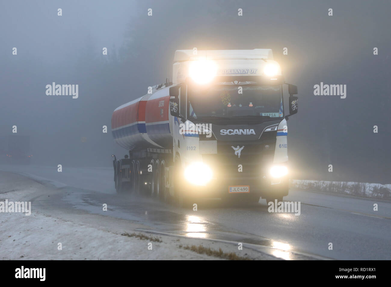 Salo, Finlandia - 28 dicembre 2018: fari luminosi di nuova generazione Scania R520 autobotte di MM Tolvanen attraverso una fitta nebbia sulla autostrada d'inverno. Foto Stock