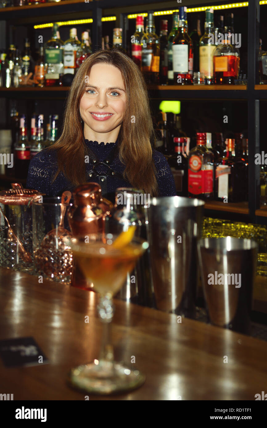 Barista ragazza che serve cocktail a un cliente Foto Stock