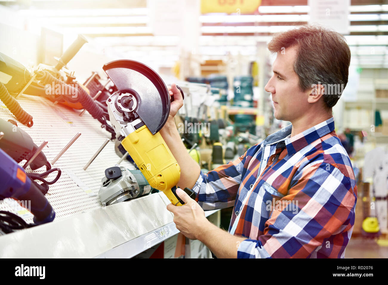 L'uomo shopping per smerigliatrice angolare in negozio di ferramenta di close-up Foto Stock