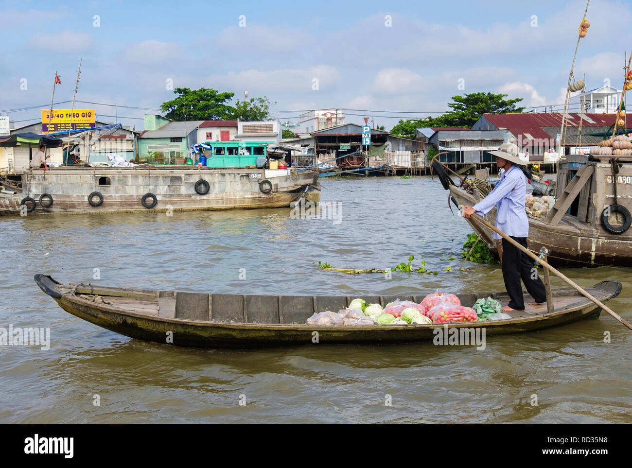 L'uomo vendere verdure da una piccola barca tradizionale nel mercato galleggiante sul Fiume Hau. Can Tho, Delta del Mekong, Vietnam Asia Foto Stock