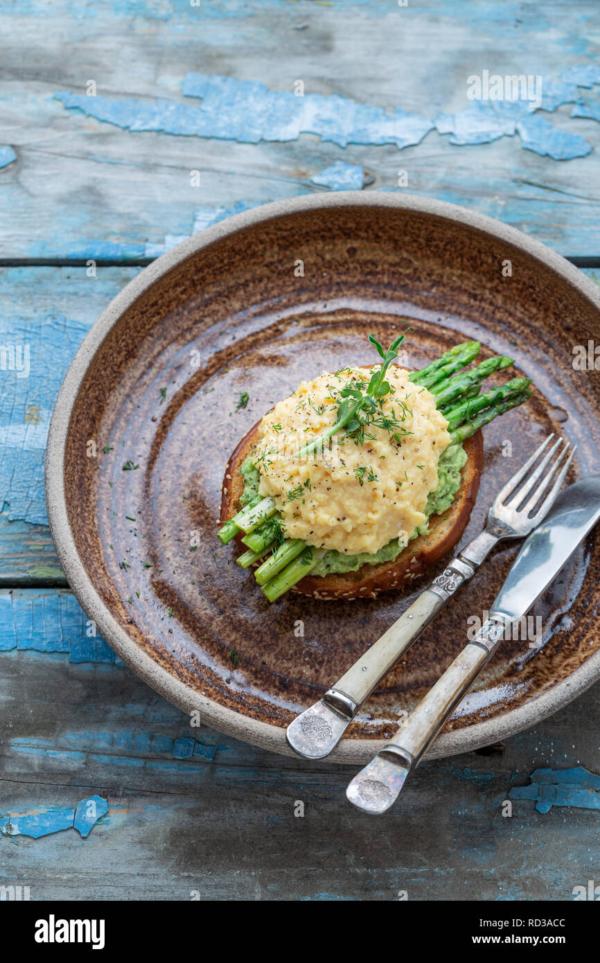 Uova strapazzate con asparagi e avocado su toast, spazio di copia Foto Stock