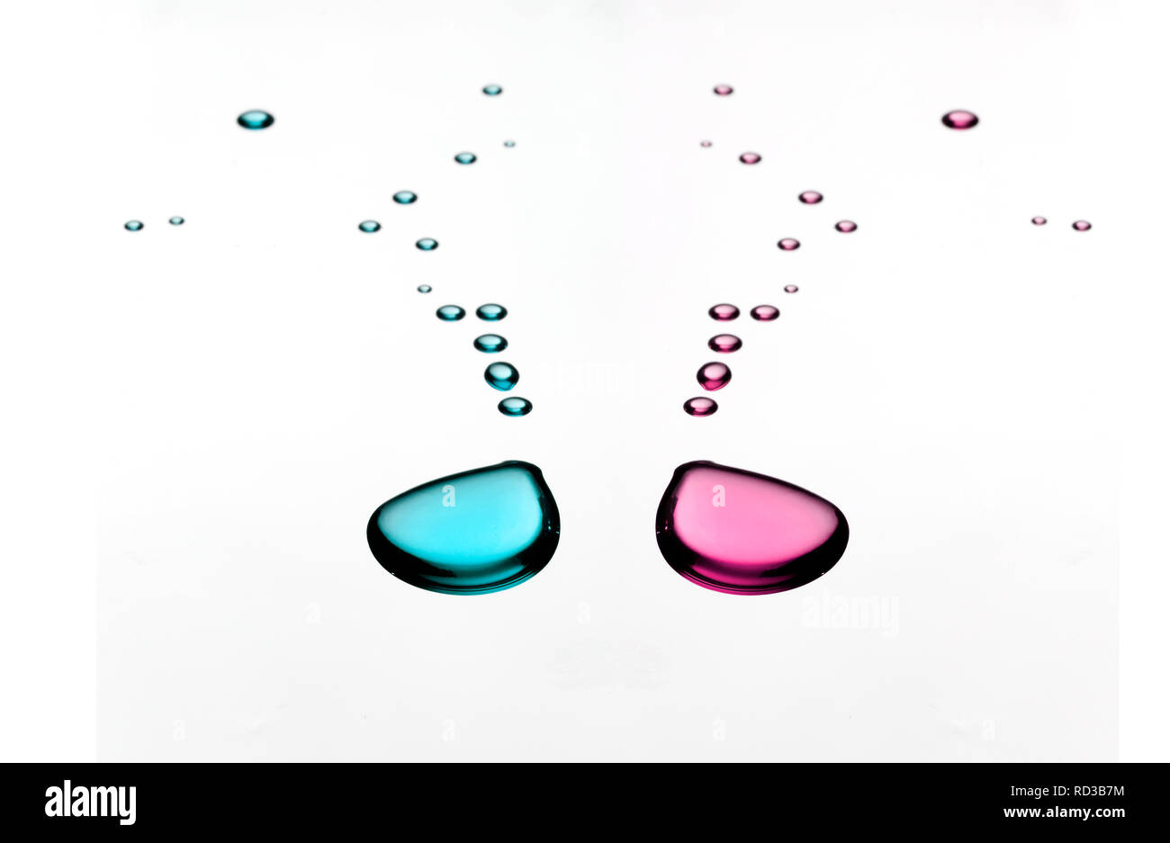 Blu e rosa goccioline di liquido su sfondo bianco Foto Stock