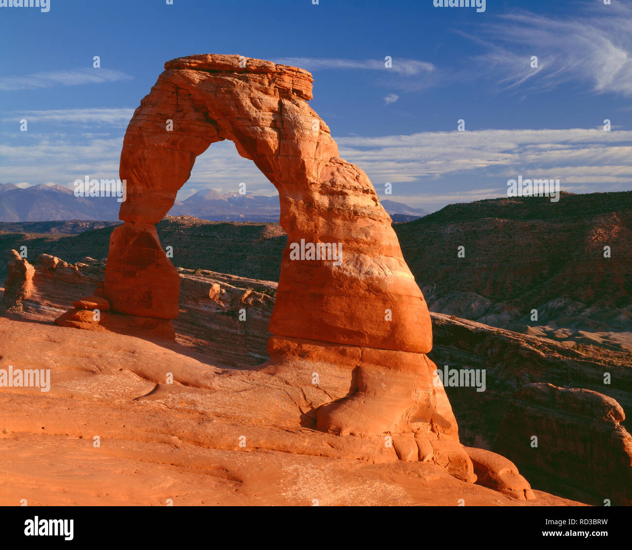 Stati Uniti d'America, Utah, Arches National Park, luce della sera su 45ft tall Delicate Arch, che è composto di Entrada in pietra arenaria, e distante La Sal Mountains. Foto Stock
