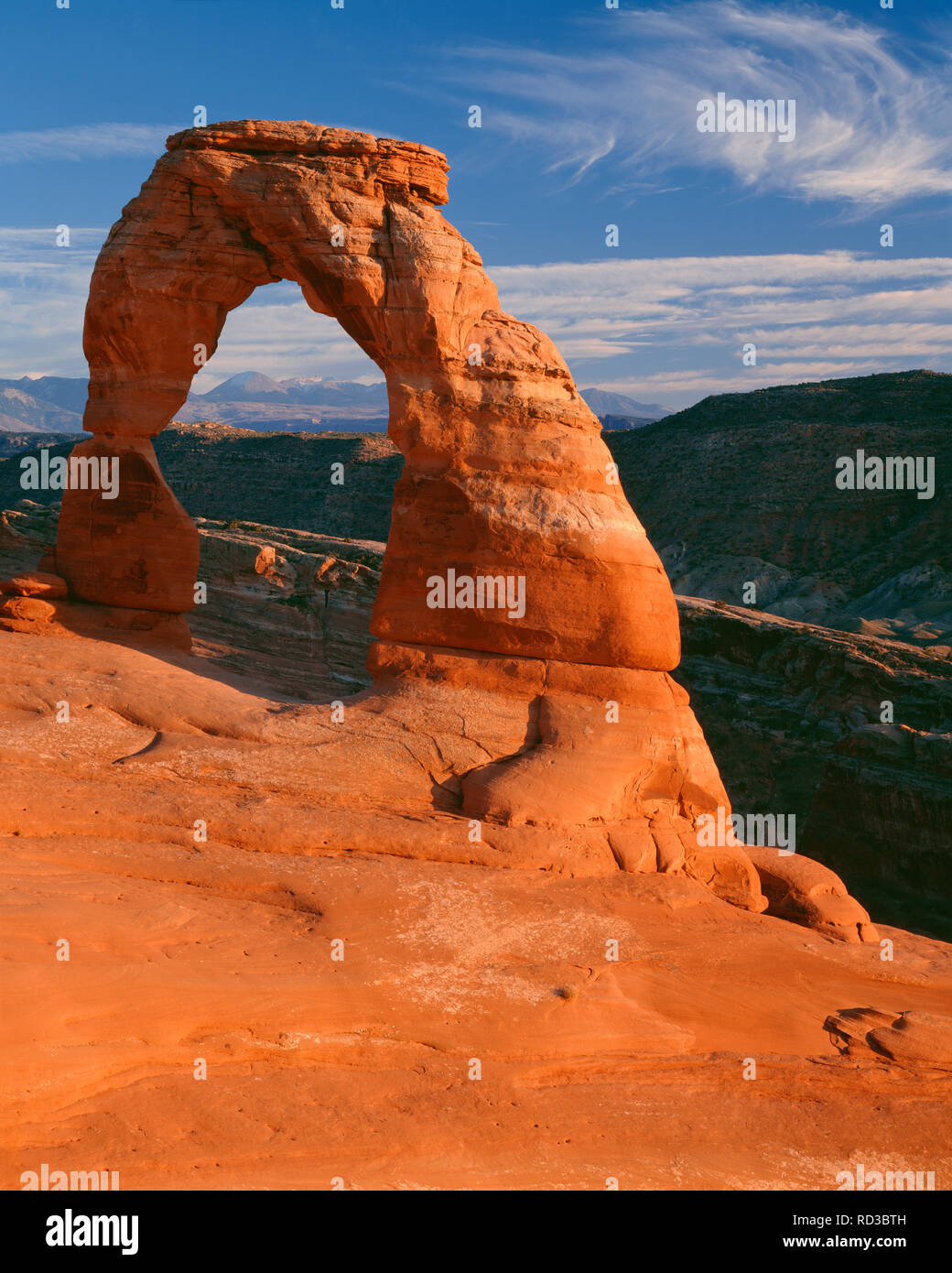 Stati Uniti d'America, Utah, Arches National Park, luce della sera su 45ft tall Delicate Arch, che è composto di Entrada in pietra arenaria, e distante La Sal Mountains. Foto Stock