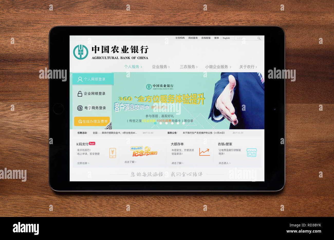 Il sito web della Banca agricola di Cina è visto su un tablet iPad, il quale è appoggiato su un tavolo di legno (solo uso editoriale). Foto Stock