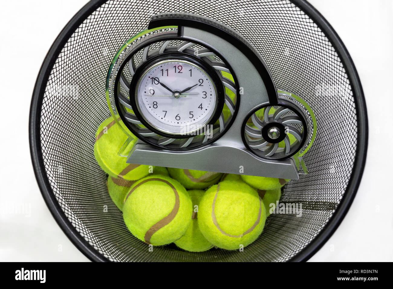 Palle da tennis e un orologio in un cestino Foto Stock