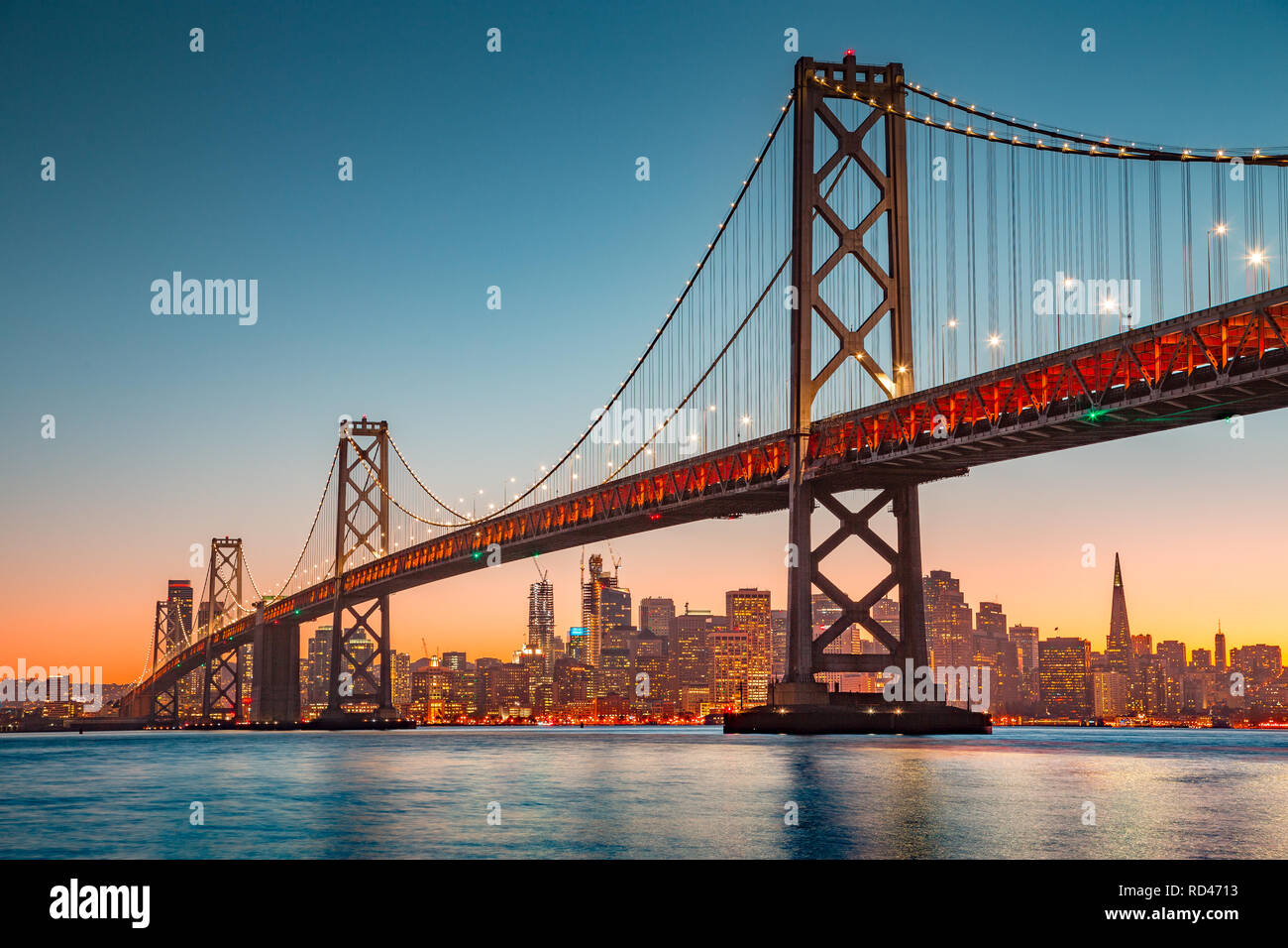 Classic vista panoramica dello skyline di San Francisco con il famoso Oakland Bay Bridge illuminato nel bellissimo golden luce della sera al tramonto in estate Foto Stock