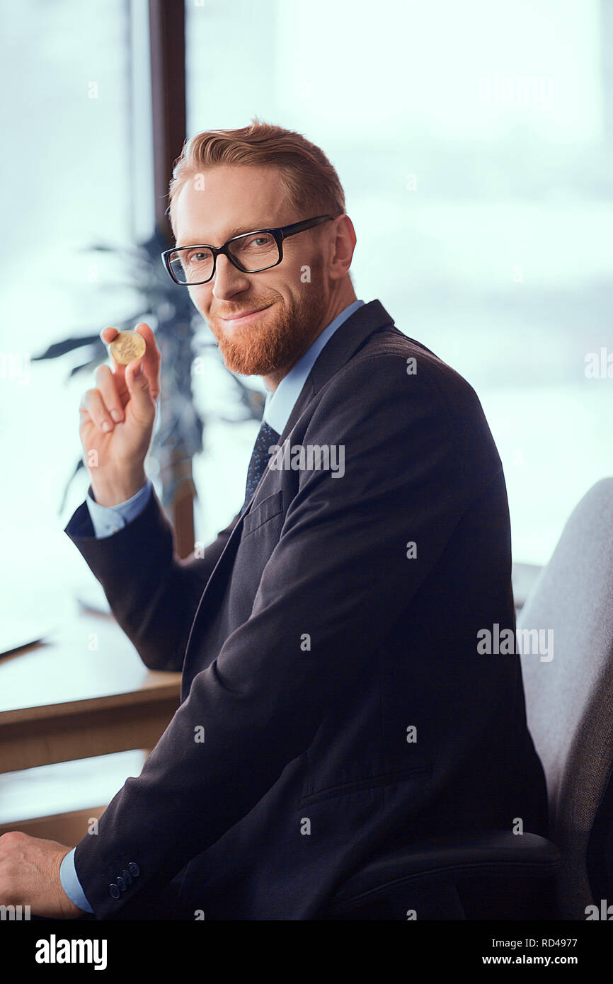 Moneta in oro in mano Foto Stock