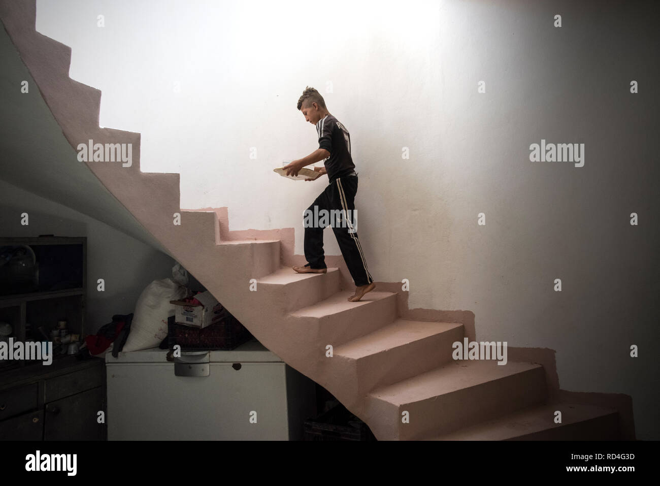 Un ragazzo visto che trasportano l'acqua per le persone che lavorano per la ricostruzione. In agosto 2014, lo Stato islamico catturato Sinjar, la città principale della popolazione Yazidi in Iraq. Ora, con la città in rovine e Nazioni Unite in Iraq e UN-Habitat hanno iniziato un recupero urbanistico programma in gran parte finanziato dal governo della Repubblica federale di Germania. Questo programma impiega la gente della regione per ricostruire la maggior parte delle famiglie danneggiate. Foto Stock