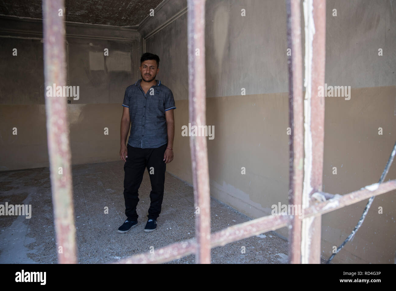 Un yazidi uomo visto in posa per un ritratto in che cosa ha usato per essere la sua casa. Ora la sua casa è in ricostruzione con l aiuto delle Nazioni Unite. In agosto 2014, lo Stato islamico catturato Sinjar, la città principale della popolazione Yazidi in Iraq. Ora, con la città in rovine e Nazioni Unite in Iraq e UN-Habitat hanno iniziato un recupero urbanistico programma in gran parte finanziato dal governo della Repubblica federale di Germania. Questo programma impiega la gente della regione per ricostruire la maggior parte delle famiglie danneggiate. Foto Stock