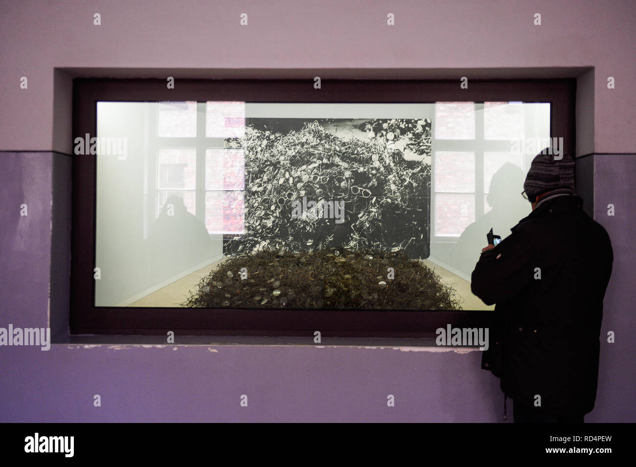 Un visitatore vede fotografare occhiali delle vittime di Auschwitz presso la ex-nazista tedesco la morte di Auschwitz-Birkenau camp. L'olocausto Giorno del Ricordo avrà luogo il 27 gennaio, dove i superstiti parteciperà alla 74anniversario della liberazione di Auschwitz celebrazioni. Foto Stock