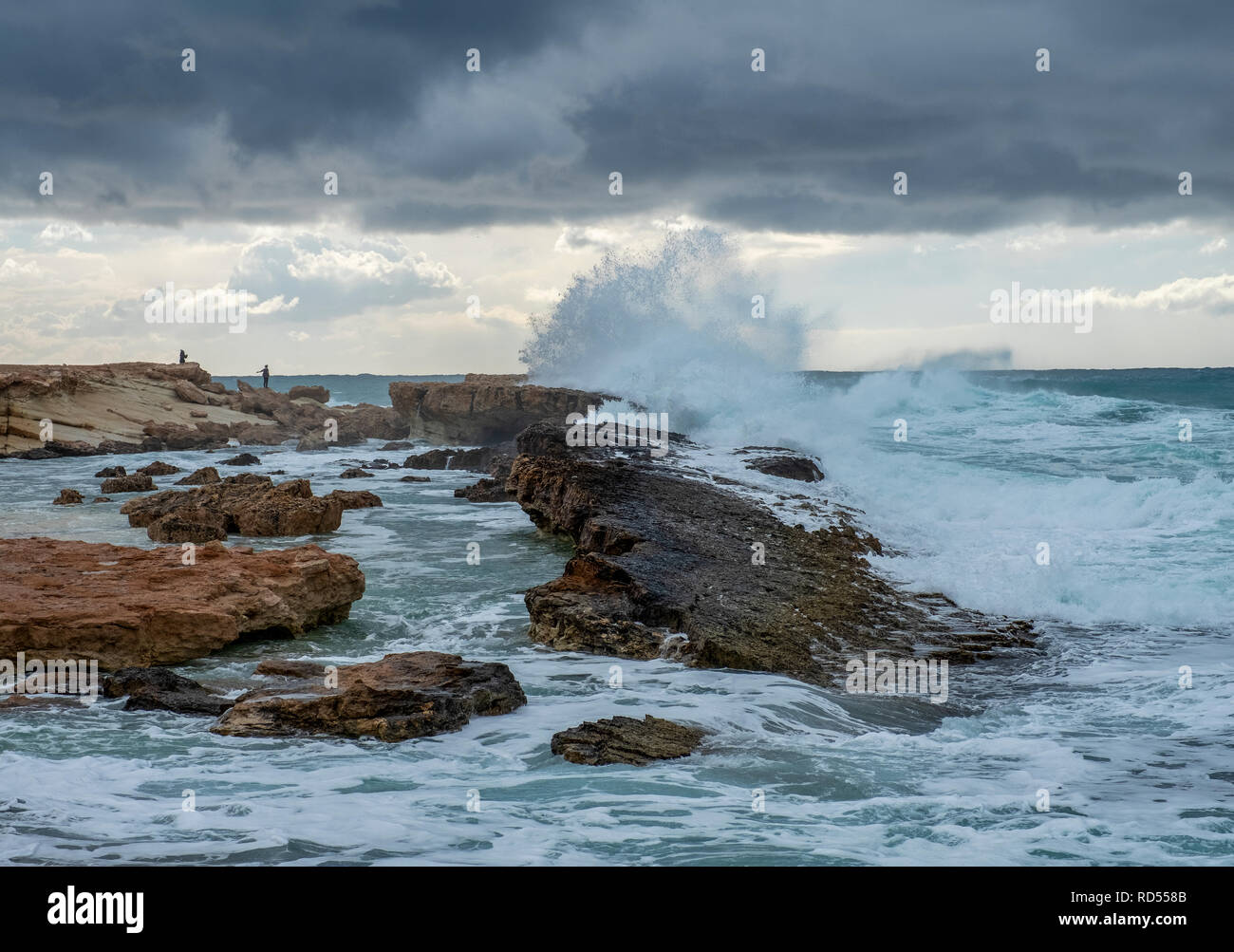 Mare mosso pastella la costa al largo di Agios Georgios, a Cipro con la piccola isola di Yeronisos dietro. Foto Stock