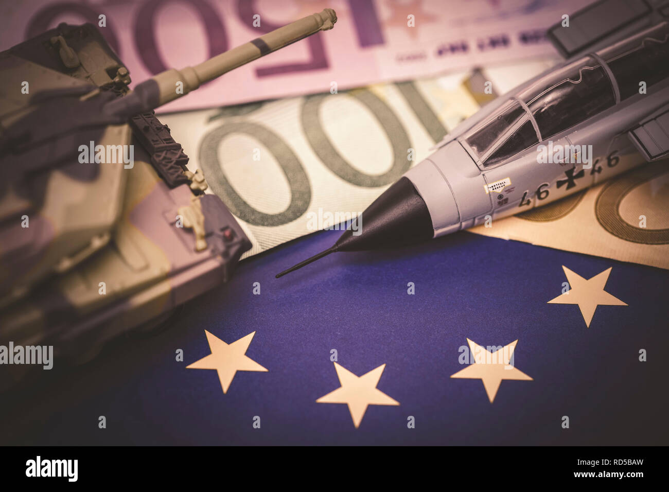 Serbatoio in miniatura e jet militare sulla bandiera UE con euronotes, foto simbolico per un esercito europeo, Miniaturpanzer und Militärjet auf UE-Fahne mit Eurosche Foto Stock