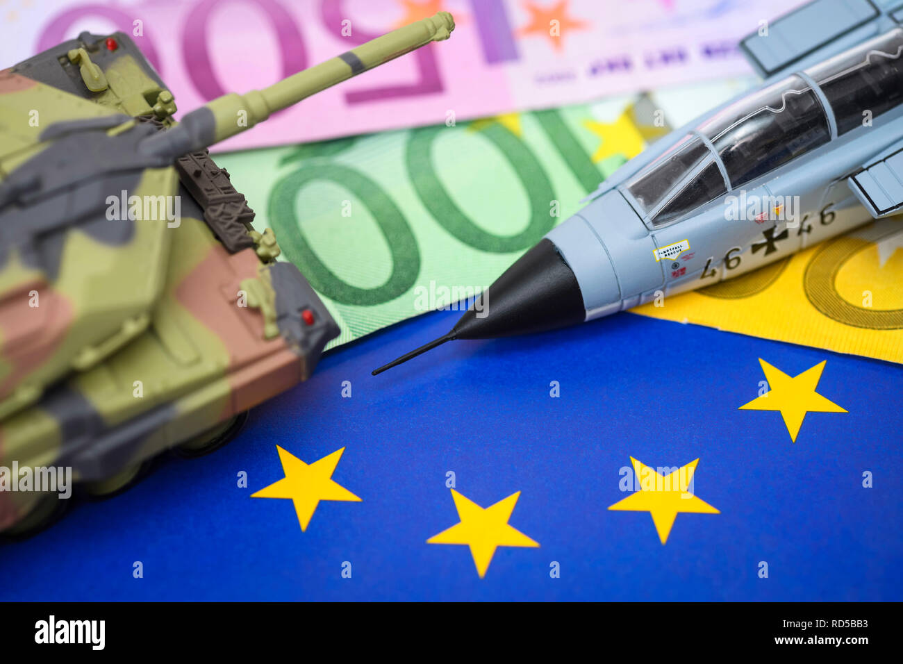 Serbatoio in miniatura e jet militare sulla bandiera UE con euronotes, foto simbolico per un esercito europeo, Miniaturpanzer und Militärjet auf UE-Fahne mit Eurosche Foto Stock