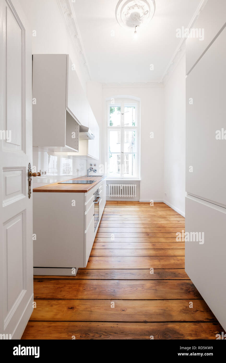 Nuovo white angolo cottura / cucina in antico palazzo restaurato con pavimento in legno Foto Stock