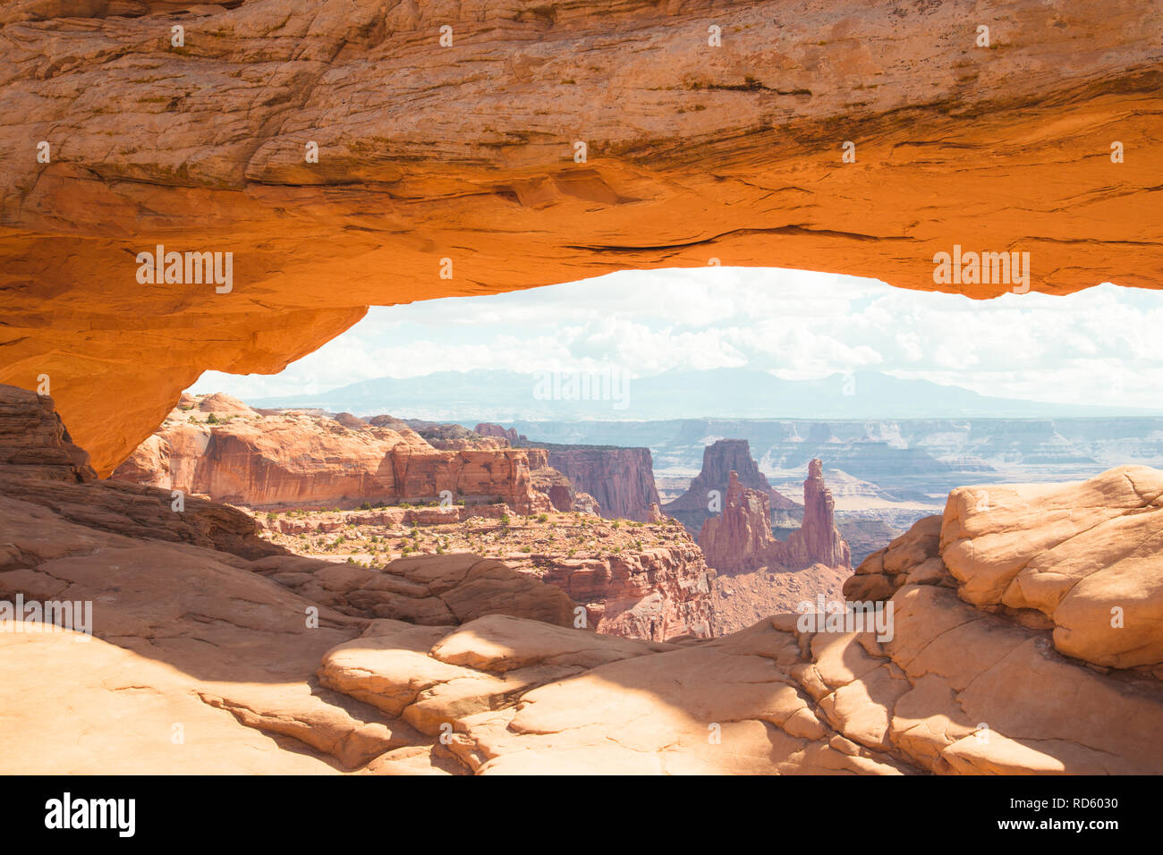 Visualizzazione classica del famoso Mesa Arch, simbolo del sud-ovest americano, illuminata a scenic golden. La luce del mattino al sorgere del sole su una bella giornata in estate Foto Stock