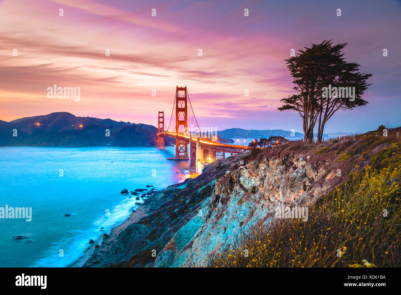 Classic vista panoramica del famoso Golden Gate Bridge visto da scenic Baker Beach in splendida post tramonto tramonto con cielo blu e nuvole al tramonto Foto Stock