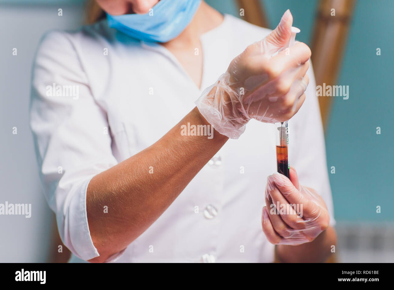 Ritratto di una bellissima femmina farmacia cercando di analizzare un sangue provetta in un laboratorio di plasma. Foto Stock