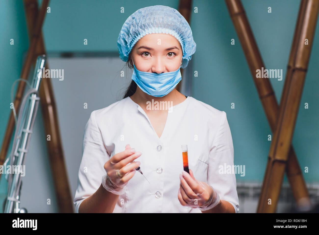 Ritratto di una bellissima femmina farmacia cercando di analizzare un sangue provetta in un laboratorio di plasma. Foto Stock