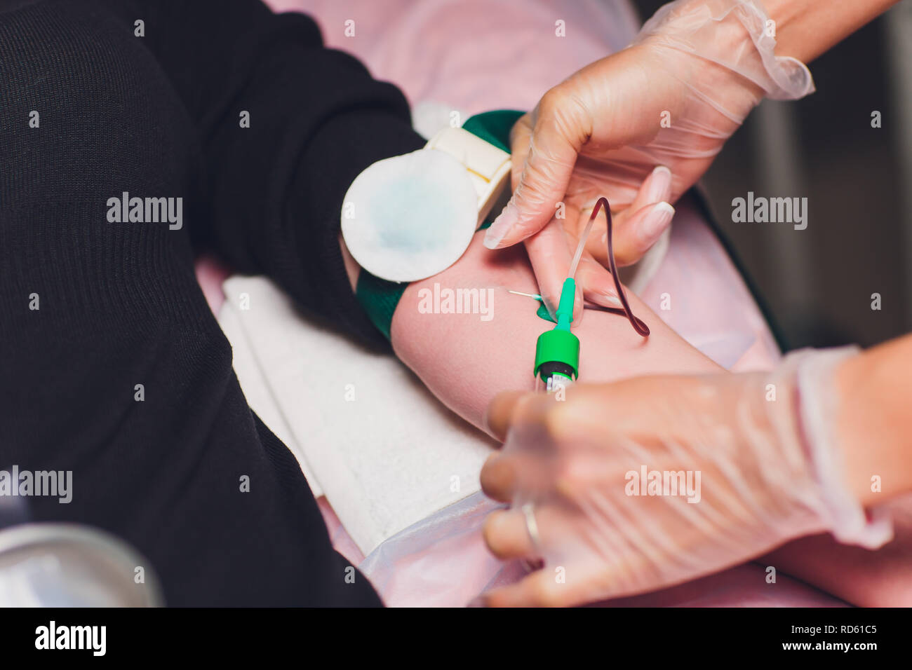 Il medico raccoglie il sangue in una siringa, Infermiere prende il sangue dalle vene sul braccio. Foto Stock